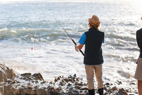 Senior man fishing with his grandson