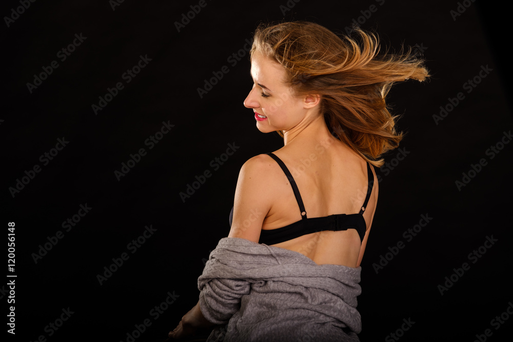 Naklejka premium Young slim model posing in underwear on black background