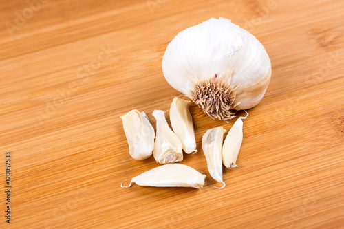 Garlic head and cloves isolated on wood background