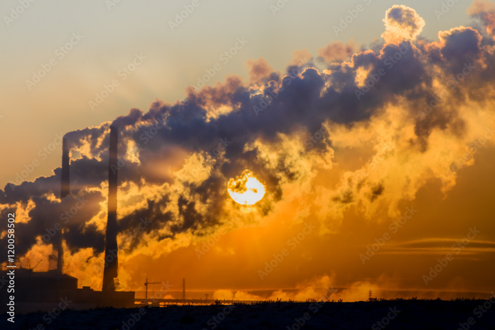 Fototapeta premium The setting sun makes its way through the dense smoke