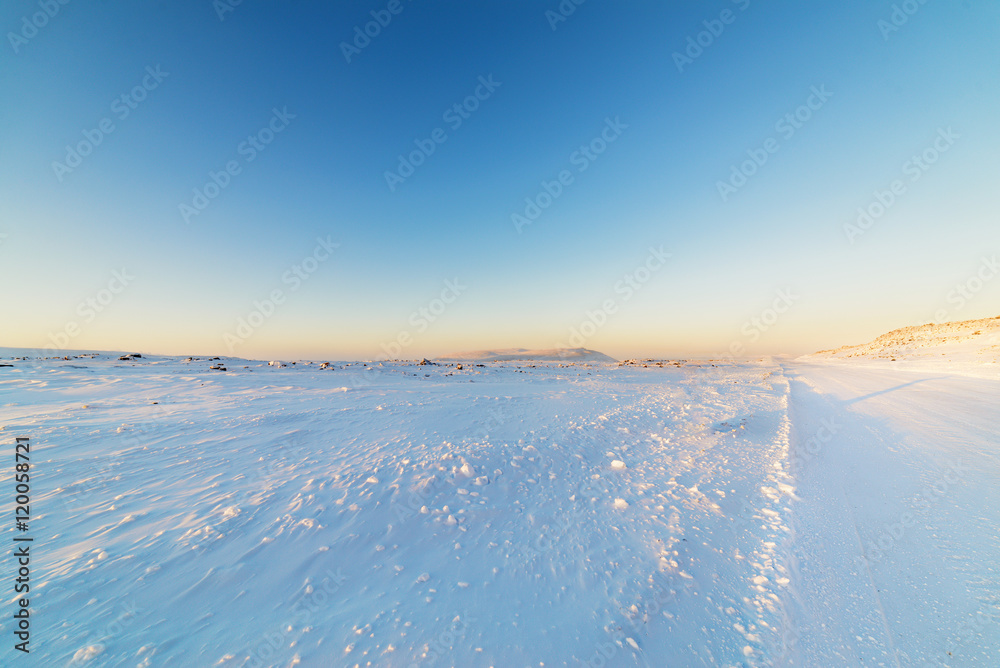 Winter road in snow-covered desert rock.
