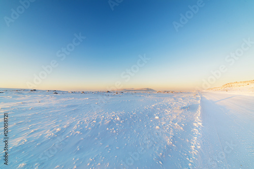 Winter road in snow-covered desert rock.