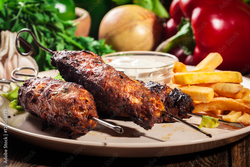 Grilled shish kebab served with fried chips and salad Stock Photo