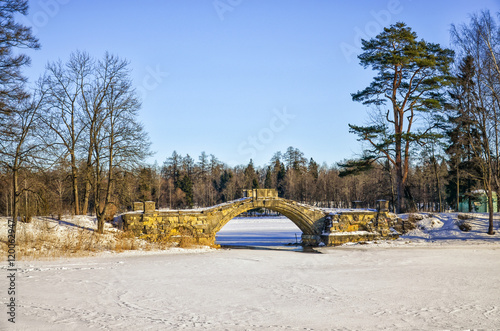 Gatchina, Leningrad oblast (Saint Petersburg suburbs), Russia. The Gorbaty bridge in the Palace Park of Gatchina Palace. Shot at a bright winter day. photo