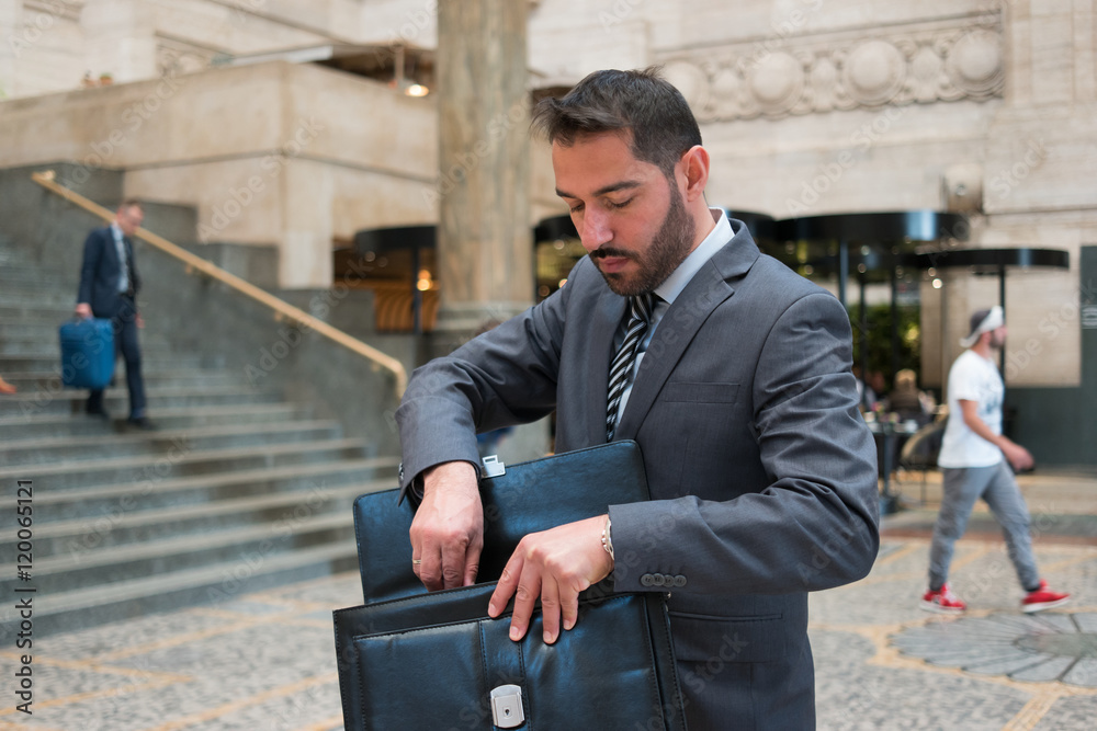 Businessman searching for something in his briefcase