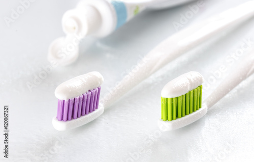 sqweezed toothpaste and two toothbrush on white background