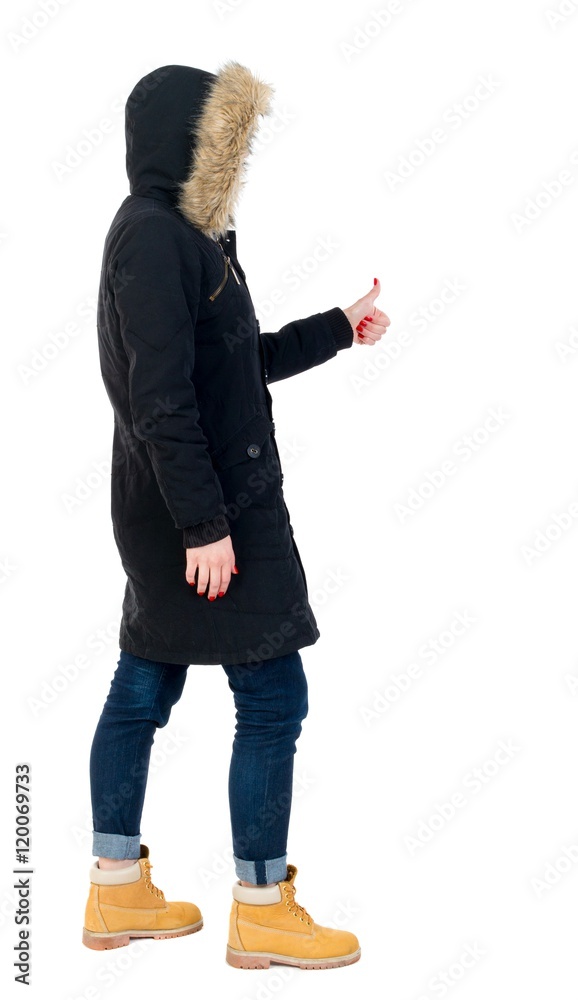 Naklejka premium Back view of woman thumbs up. girl in warm winter jacket is black with cancer and shows thumb up.