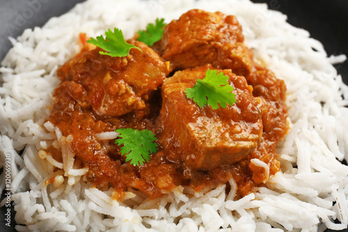 Tasty dinner with chicken curry and rice on plate, closeup photo
