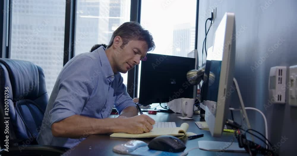 Male employee working notepad at computer in creative open-plan city office. Medium shot, recorded hand held in real time. Male employee working notepad at computer in creative open-plan city office. Medium shot, recorded hand held in real time.