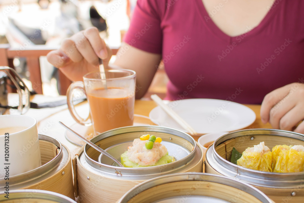 young woman eating dimsum and thai tea blur background young woman eating dimsum and thai tea blur background