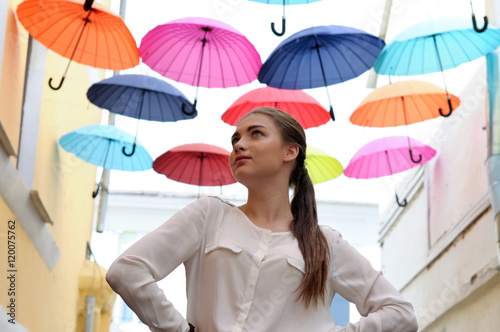 Girl posing under colorful umbrellas