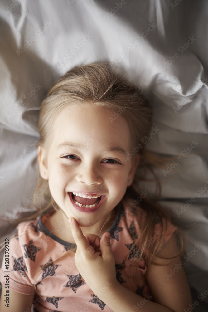 Girl laughing in her bed Girl laughing in her bed