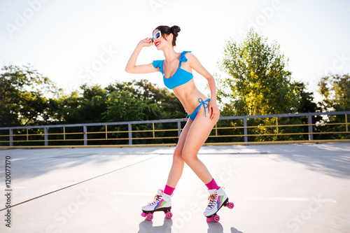 Side view of a roller girl in blue swimsuit posing