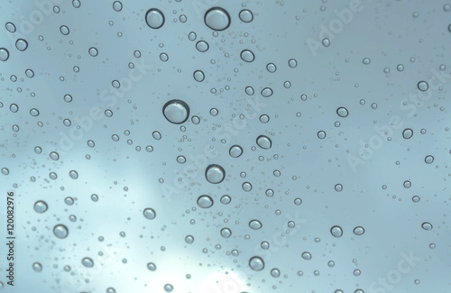 Drops of rain on glass , rain drops on clear window / rain drops with clouds / water drops on glass after rain background / water drops / Small water drops on the glass.