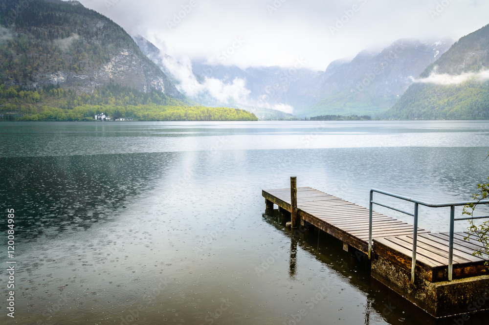 Wooden jetty in Hallstatt lake on a foggy and rainy day
