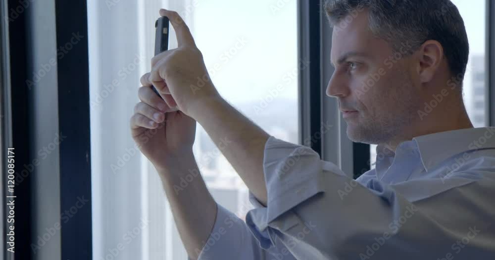 Business man takes and sends cellphone picture of Downtown Los Angeles from high office windows.  Close up, recorded hand held in real time.