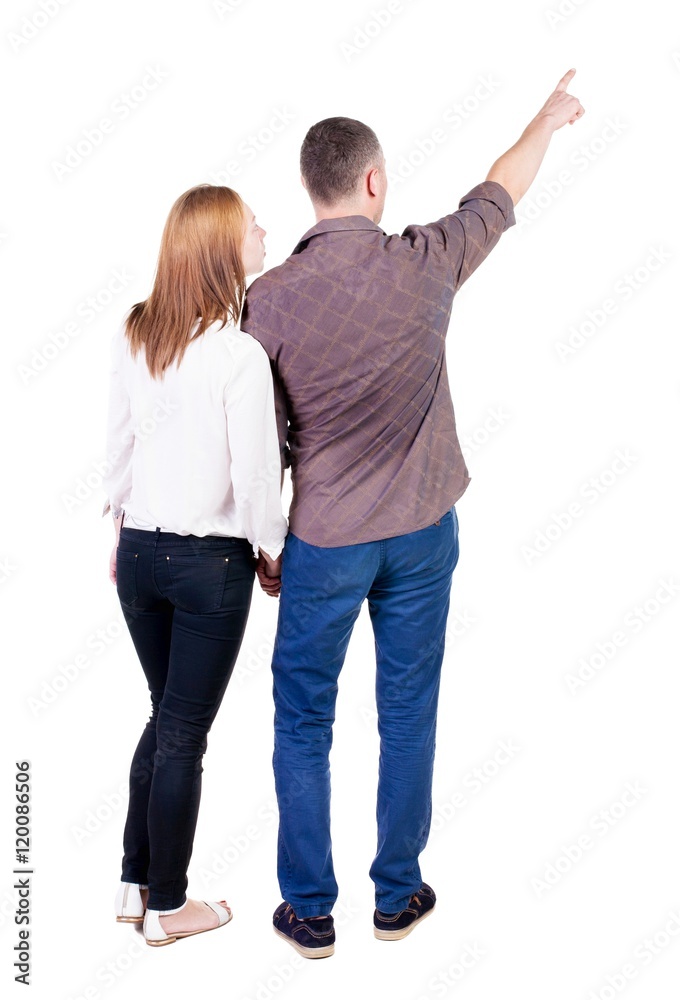 young couple pointing at wal Back view (woman and man). Rear view ...