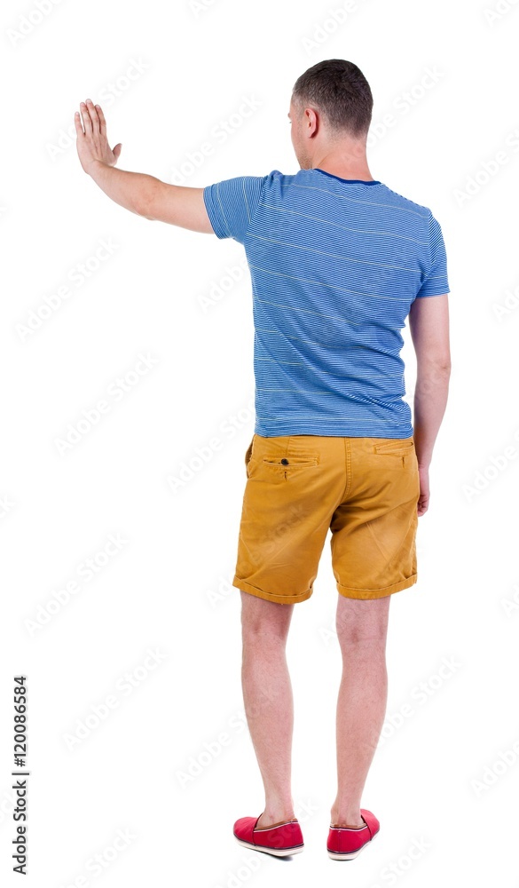  back view of man. Young man in shorts presses down on something. Isolated over white background. Rear view people collection. backside view of person. she holds his hand open, palm forward