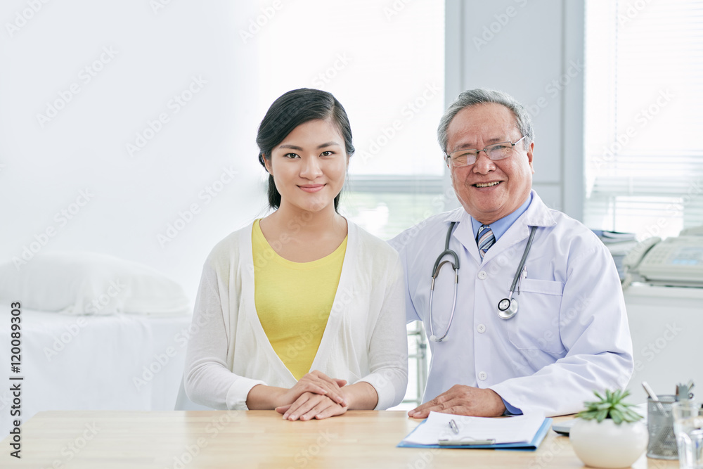 Smiling hugging senior doctor and his female patient Smiling hugging senior doctor and his female patient