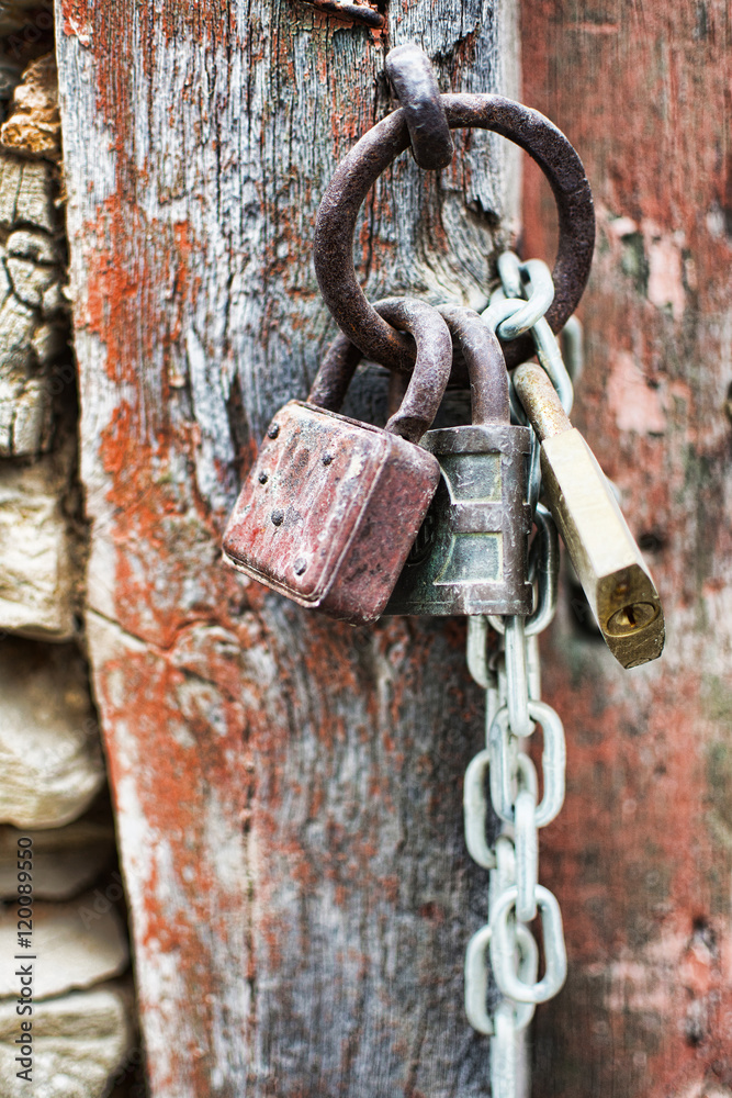 Vintage Corroded Padlocks  with Chain on a Ancient Red Gate Background. Old Rusty Padlocks on a Wooden Door.