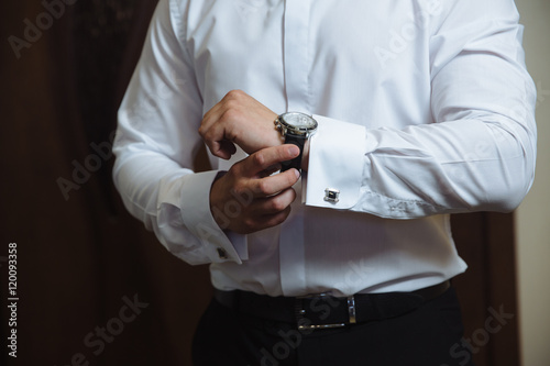 Businessman checking time on his wristwatch. men's hand with a watch.