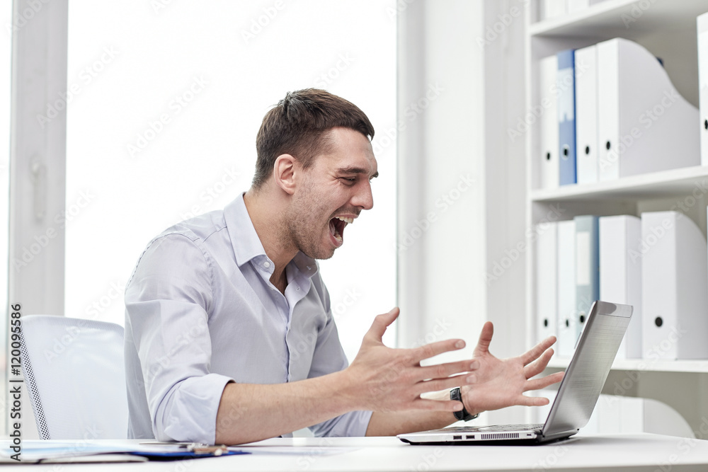 angry businessman with laptop and papers in office angry businessman with laptop and papers in office