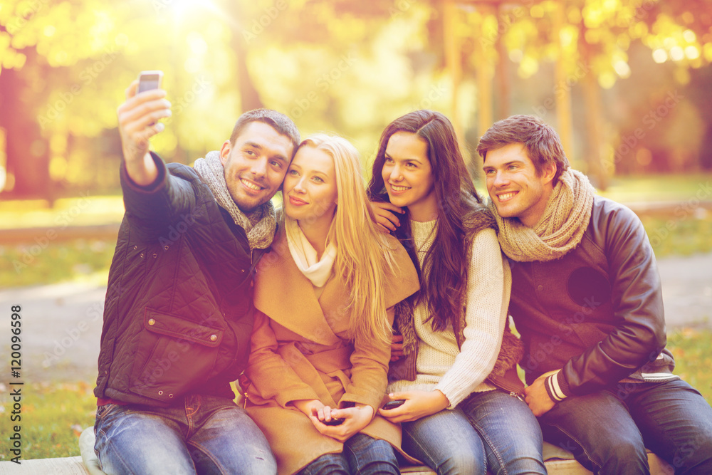 group of friends with photo camera in autumn park group of friends with photo camera in autumn park