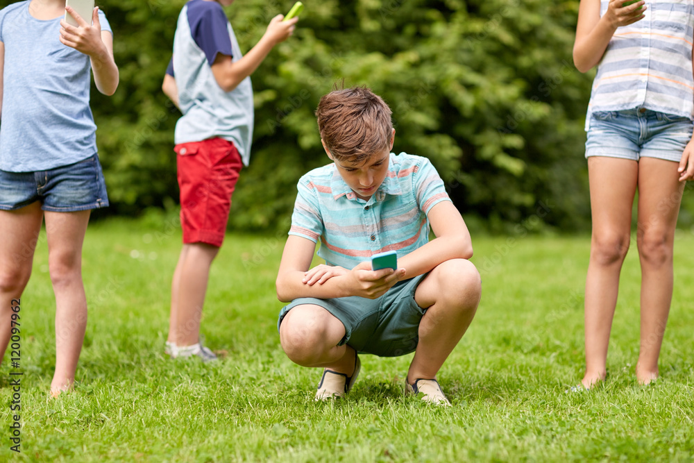 Obraz premium kids with smartphones playing game in summer park