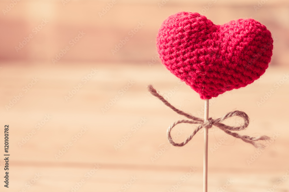 love heart yarn on wood stick with wood background.