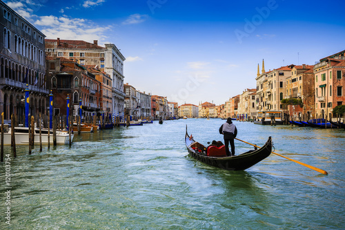 Gondolier sailing a gondola and view of the Grand Canal, Venice, Italy