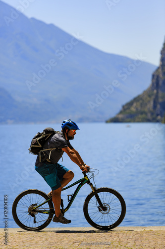 Cycling man at the lake Shore of Garda lake in Italy.