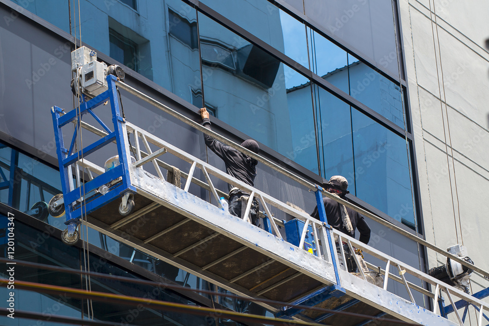 group of workers cleaning windows service on high rise building