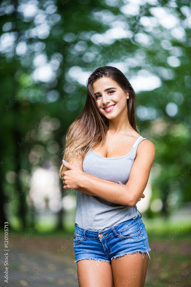 Beautiful young woman walking in summer park Beautiful young woman walking in summer park