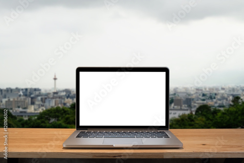 Laptop with blank screen on table. Osaka japan background.