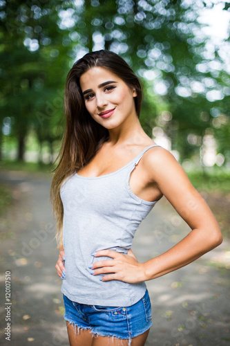 Outdoors portrait in park of a beautiful tanned teen student girl.