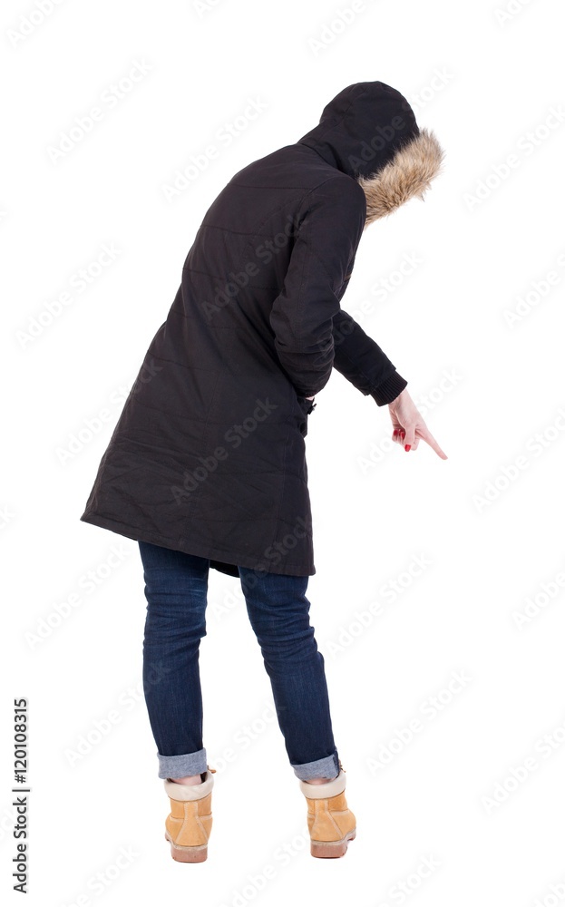 Naklejka premium Back view of pointing young women in parka. Young girl gesture. Rear view people collection. backside view of person. Isolated over white background. 