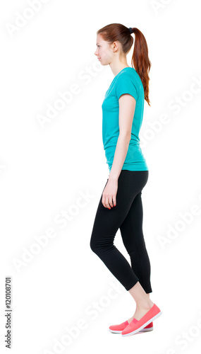 side view of walking woman in sports tights. beautiful girl in motion. backside view of person. Rear view people collection. Isolated over white background. Sports girl goes to the left.