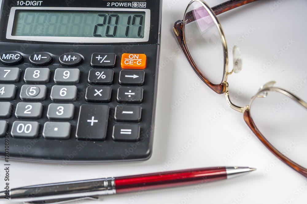 New Year Date 2017 On Calculator with eyeglasses and ballpoint pen on White Background New Year Date 2017 On Calculator with eyeglasses and ballpoint pen on White Background