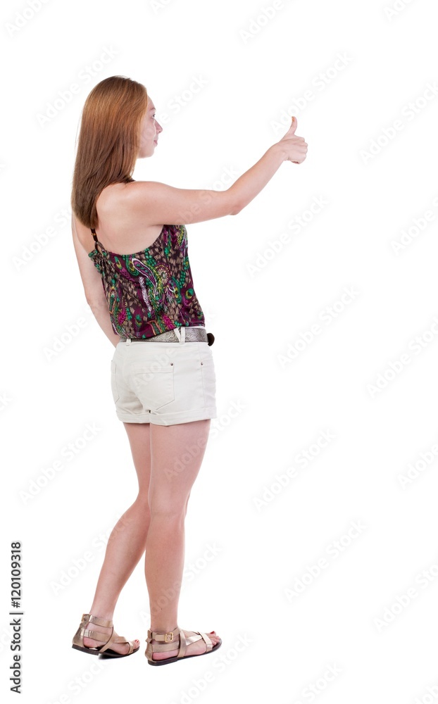 Back view of woman thumbs up. Rear view people collection. backside view of person. Isolated over white background. slender blonde in a shorts shows the symbol of success or hitchhiking Back view of woman thumbs up. Rear view people collection. backside view of person. Isolated over white background. slender blonde in a shorts shows the symbol of success or hitchhiking