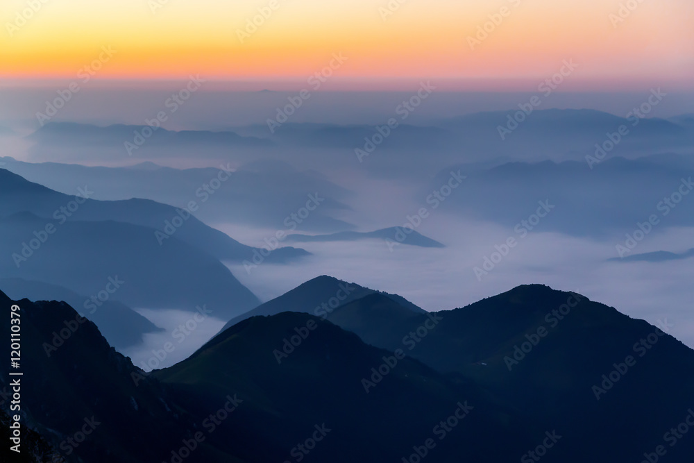 Sunrise landscape of foggy and cloudy mountains