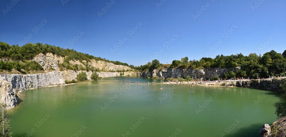 Panorama of abandoned and flooded quarry. Czech Republic.  Beautiful landscape with sun.