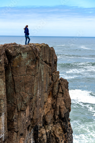 Powerful woman on cliff of rocks
