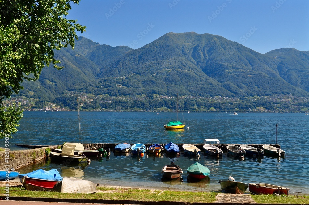 Kleiner Bootshafen mit bunten Booten in Locarno am blauen  Lago Maggiore - See, im Tessin, Schweiz