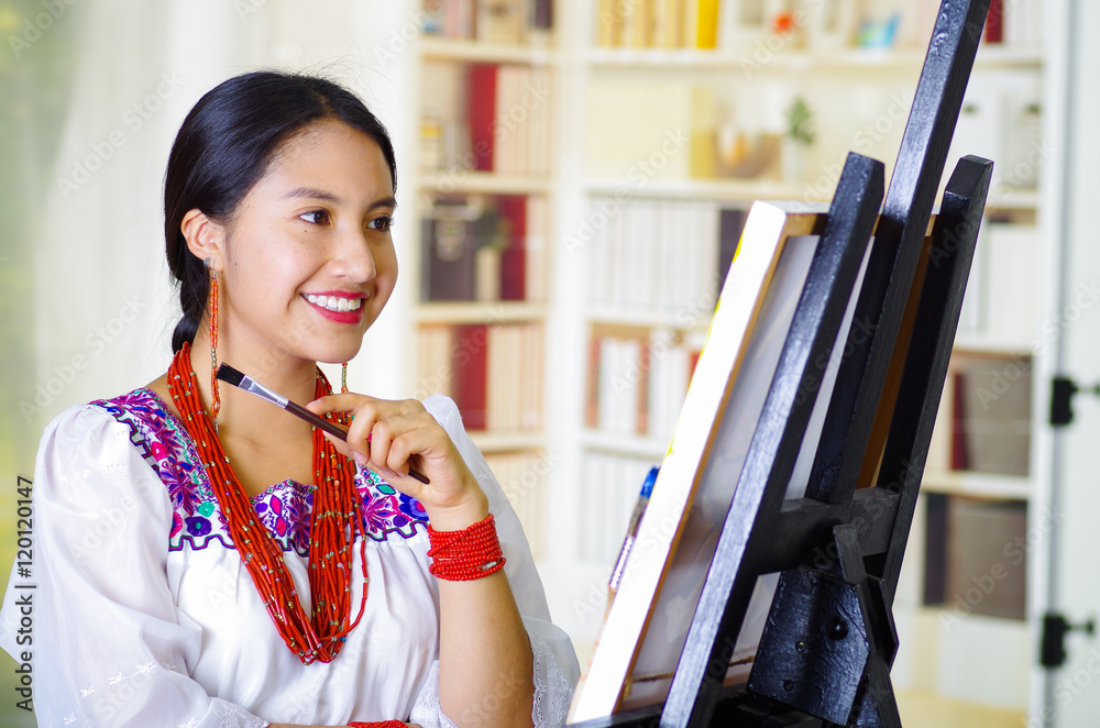 Φωτογραφία Young brunette woman wearing traditional andean clothing painting on canvas insi