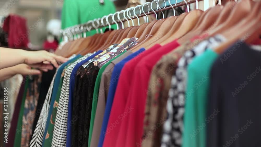 The buyer chooses a dress in a clothing boutique with women's clothing