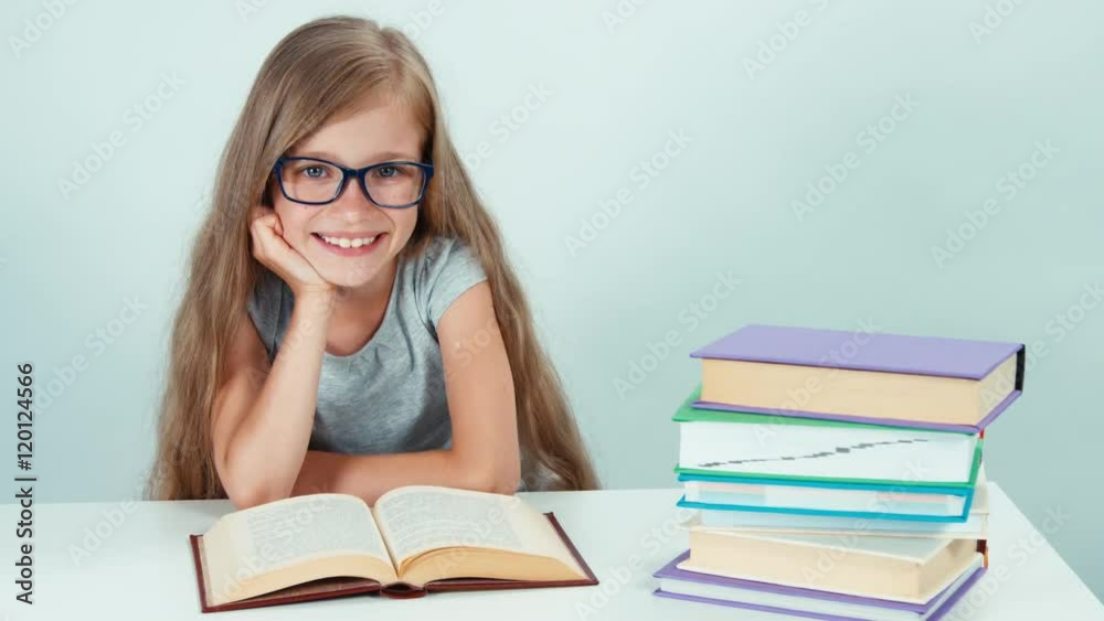 Portrait cute student girl 7-8 years reading book and smiling at the camera Portrait cute student girl 7-8 years reading book and smiling at the camera