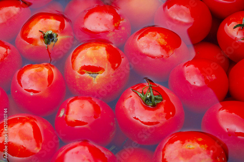 red tomatoes in the water prepared for preservation © alexmak