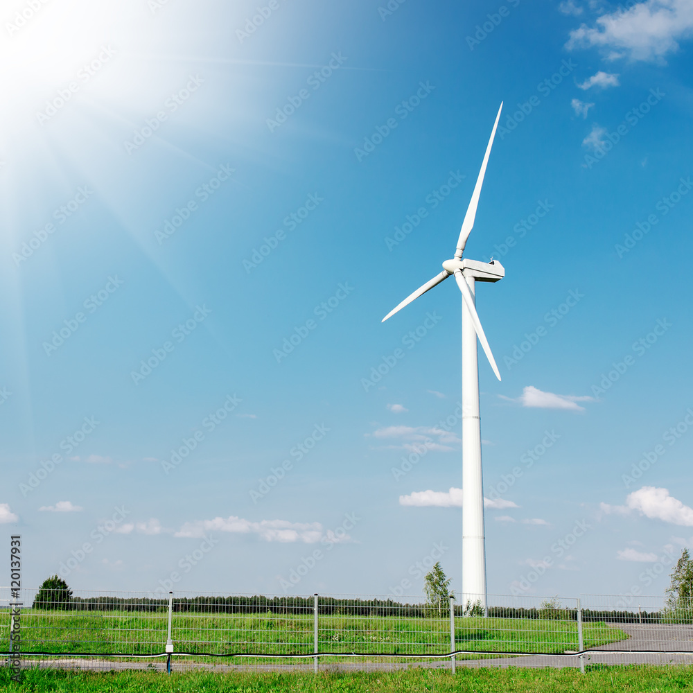 Energy windmill produce energy on blue sky at daytime Energy windmill produce energy on blue sky at daytime