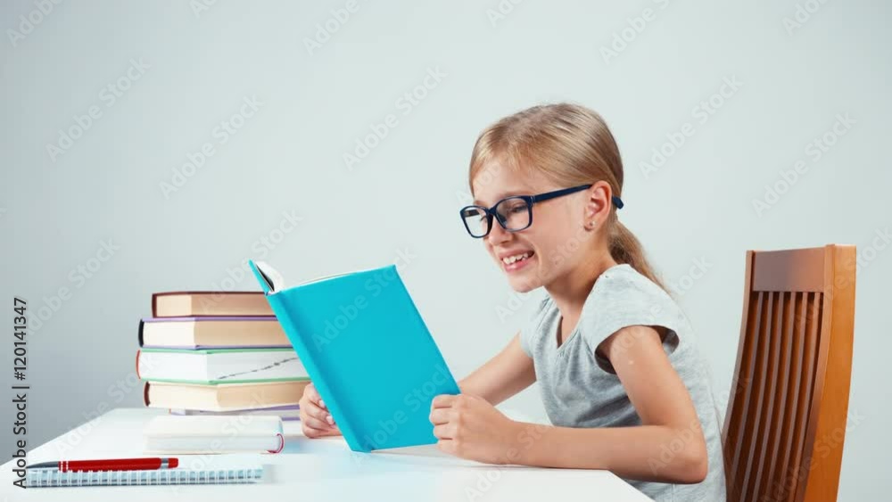 Happy schoolgirl 7-8 years old reading her book and reading with smile Happy schoolgirl 7-8 years old reading her book and reading with smile