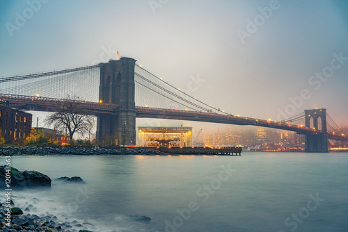 Brooklyn bridge and Manhattan at foggy evening  New York City